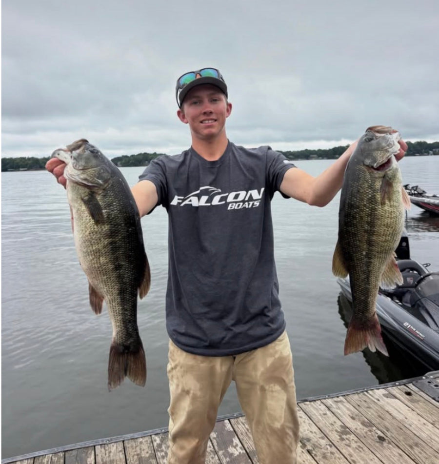 Angler holding two bass at the dock